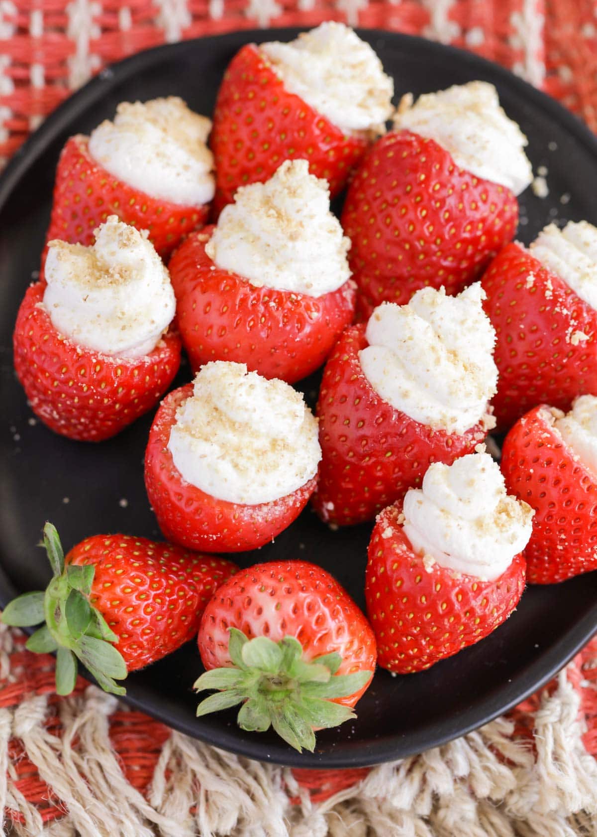 A plate full of cheesecake stuffed strawberries