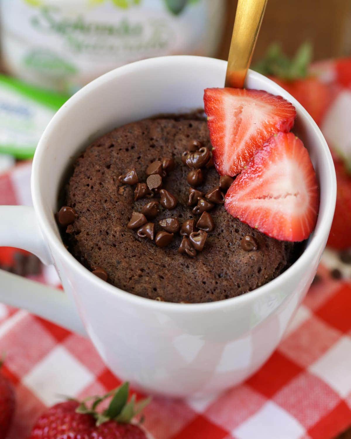 Chocolate Cake in a mug with chocolate chips and strawberries