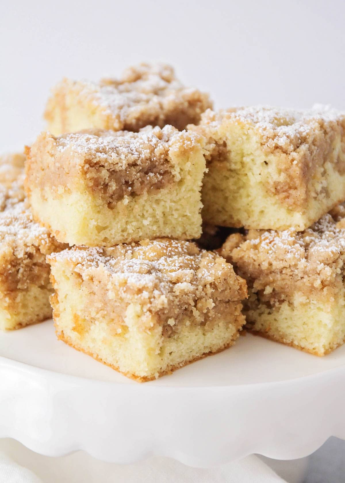 Slices of ny style crumb cake on a cake stand